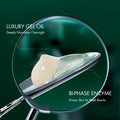 Close-up of a cosmetic dropper holding a clear glass droplet over a silver applicator, with text reading 'LUXURY GEL OIL' and 'BI-PHASE ENZYME' on a dark green background.